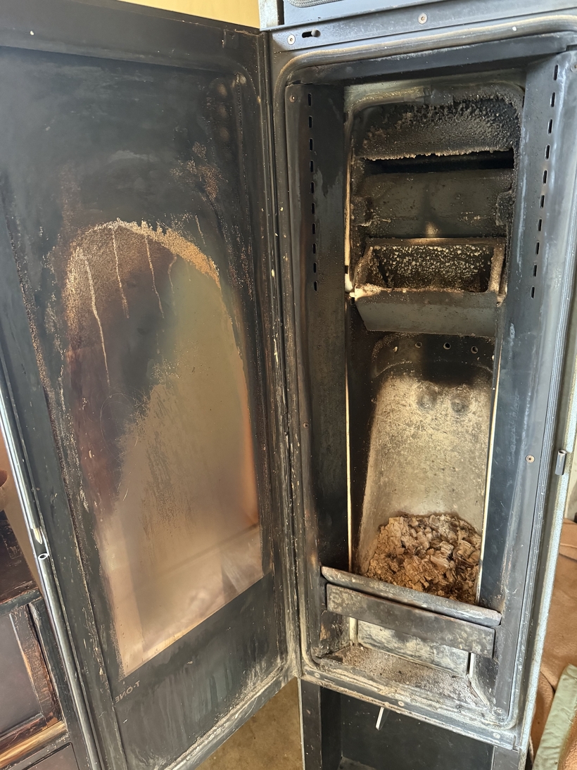 不完全燃焼気味で使用されたストーブ。完全燃焼されて燃焼温度が上がればこのように黒くなる事はありません。ガラスが黒くなってしまったのは少し不完全燃焼になってしまって温度が上がる前にガラス表面で可燃性のガスが冷やされ結露した状態です。着火直後によく見られる症状ですが、燃焼温度が上がればガラスも綺麗になるのですが、黒く汚れたままの状態はその後の燃焼温度が低くかった証拠です。蓄熱ストーブの場合燃焼温度が低いと蓄熱が充分されず放熱時間が短くなってしまいます。また最悪蓄熱されず暖かくならない場合があります。
